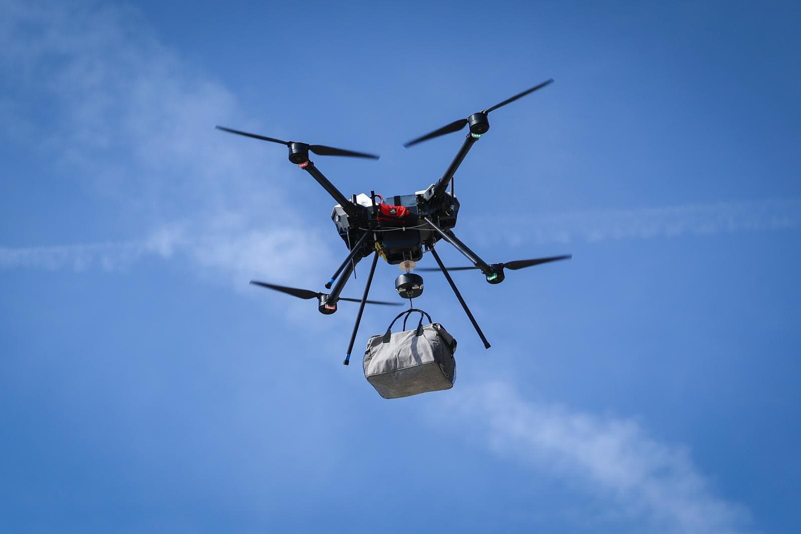 Close-up of the drone carrying a sealed bag on the winch