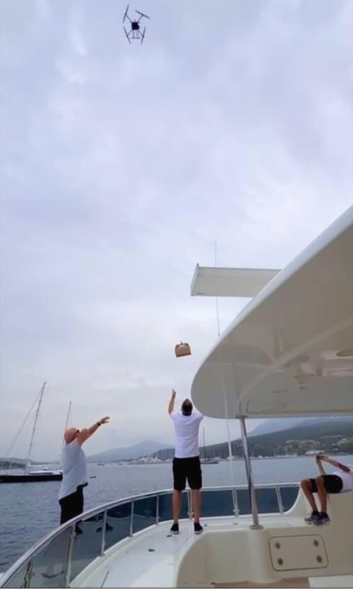 Crew catching the parcel lowered by winch onto the deck